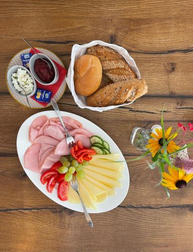 a plate of food with meats and cheese and bread at Fleischerei - Apartments, Cafe & Weinbar in Hinterstoder