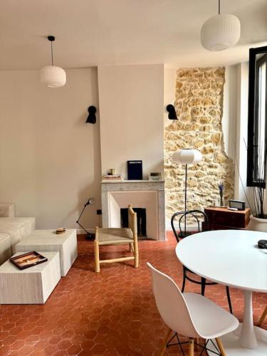 un salon avec une table et une cheminée dans l'établissement T2 typique et décoré avec goût - quartier Vauban, à Marseille