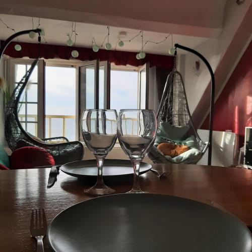 - une table avec 2 verres à vin et 2 chaises dans l'établissement MH02 - L'évasion vue mer époustouflante, à Mers-les-Bains