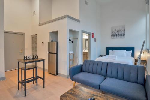 a living room with a blue couch and a bed at Bright and Modern Studio in Louisville # 301 in Louisville