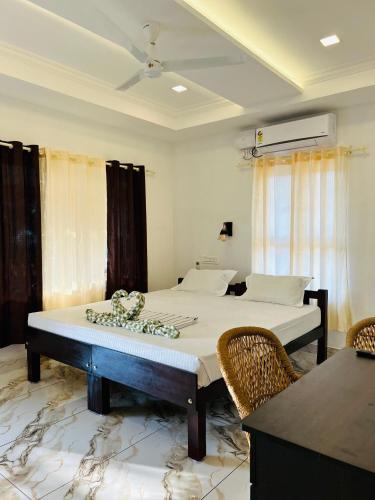 a bedroom with two beds and a table and chairs at Marari Beach Homestay in Mararikulam