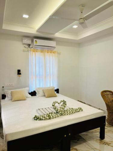 a large bed with a bow on top of it at Marari Beach Homestay in Mararikulam