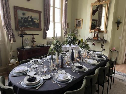 a dining room with a table with plates and dishes at Hôtel Château des Jacobins in Agen