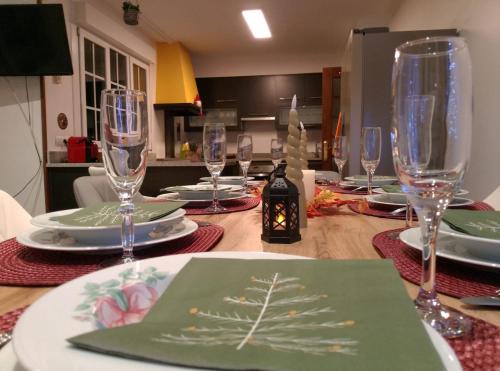 einem Holztisch mit Weingläsern und Tellern darauf in der Unterkunft Casa Quercus Galicia a 17 minutos de Compostela! in A Estrada