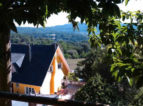 an orange house with a black roof on a hill at Casa Quercus Galicia, a 17 minutos de Santiago! in A Estrada