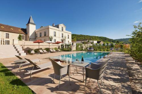 a pool with chairs and a table in front of a building at Prosper Maufoux - Château de Saint-Aubin in Saint-Aubin