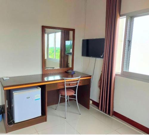 a desk with a mirror and a chair in a room at KP Hotel Udonthani in Amphoe Kumphawapi