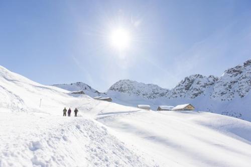 two people skiing on a snow covered mountain at Berghaus Lutzklang in Raggal