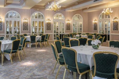 a room with tables and chairs and chandeliers at Moor Hall Hotel & Spa in Sutton Coldfield