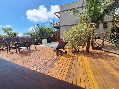 a wooden deck with a table and chairs on it at Flats Baia dos Porcos in Fernando de Noronha