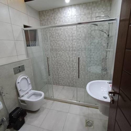 a bathroom with a shower and a toilet and a sink at Laperla luxury family apartment one in Amman