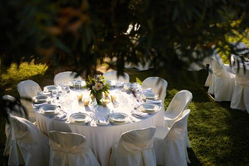a white table with white chairs and plates on it at Domotel Xenia Volos in Volos