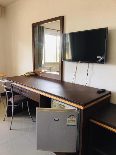 a desk with a television and a mirror on a wall at KP Hotel Udonthani in Amphoe Kumphawapi
