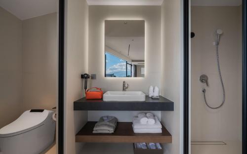 a bathroom with a sink and a toilet and a mirror at Neo-garden in Dali