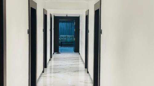 a hallway with black and white walls and tile floors at Hotel Sai Palace Inn in Puttaparthi