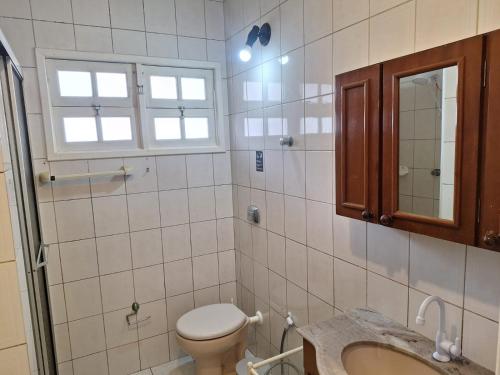 a bathroom with a toilet and a sink and a mirror at Sieber's Residence in Florianópolis