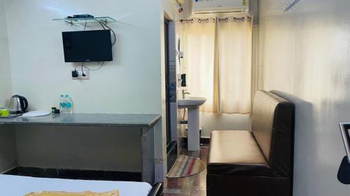 a room with a desk and a tv in it at Hotel Sai Palace Inn in Puttaparthi