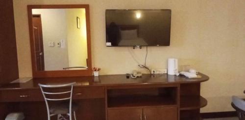 a bathroom with a vanity with a sink and a mirror at KP Hotel Udonthani in Amphoe Kumphawapi