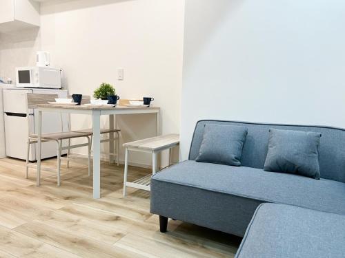 a living room with a blue couch and a table at Ikebukuro Area 1F03 NishiikeApartment in Tokyo