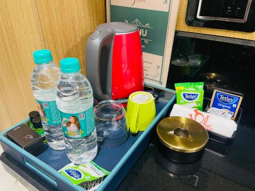 a tray with water bottles and other items on a counter at Hotel Sai Palace Inn in Puttaparthi