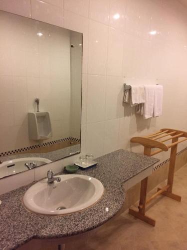 a bathroom with a sink and a mirror at KP Hotel Udonthani in Amphoe Kumphawapi