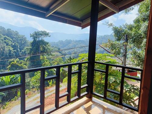 a room with a balcony with a view of the forest at Motho Homestay โมโทโฮมสเตย์ in Chom Thong