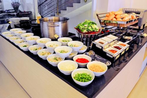 a buffet with bowls of food on a counter at May Ngu Sac - Iridescent Clouds Hotel in Nha Trang