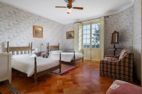 una camera da letto con due letti e un ventilatore a soffitto di Casa rural Hacienda San Felipe a Gerena