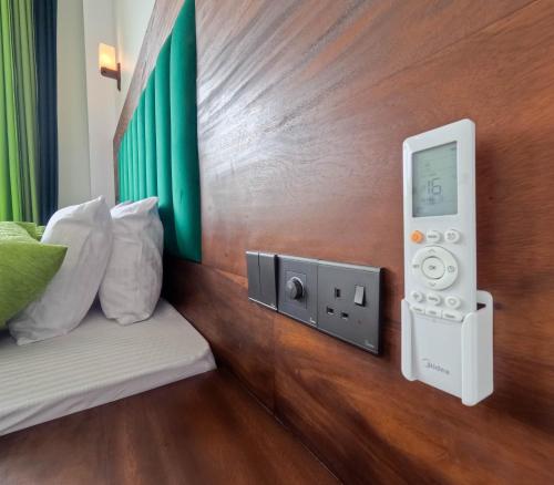 a room with a bed and a wall with a control panel at Chabee N Jay Villa Madiha Beach in Matara