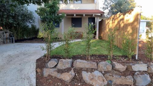 a stone retaining wall in front of a house at חדרי אירוח בהט in Ein Zivan
