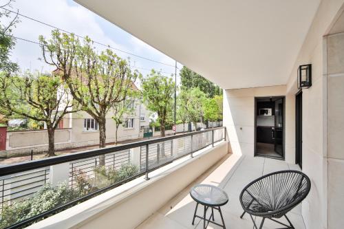 d'un balcon avec deux chaises et une vue. dans l'établissement Blue Nights Appartements 69, à Chennevières-sur-Marne