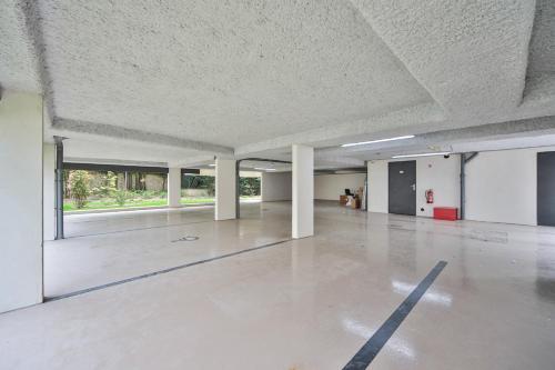 une pièce vide avec un sol en béton et des plafonds blancs dans l'établissement Blue Nights Appartements 69, à Chennevières-sur-Marne