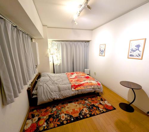 a bedroom with a bed and a table and a rug at Asakusa Tokyo T'sRoom in Tokyo
