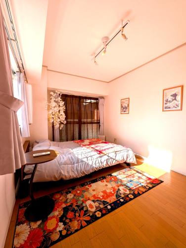 a bedroom with a bed and a table and a rug at Asakusa Tokyo T'sRoom in Tokyo