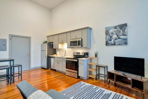 una cocina con armarios blancos y una mesa en una habitación en Bright and Modern Studio in Louisville # 307, en Louisville