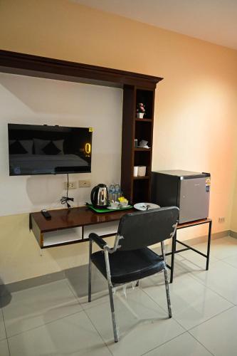 a room with a table and a chair and a television at Royal Star Suites pattaya in Pattaya South