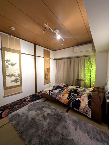 a bedroom with a bed and a window and a rug at Asakusa Tokyo T'sRoom in Tokyo