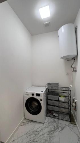 a washing machine in a corner of a room at Diamond Apartment in Grudziądz