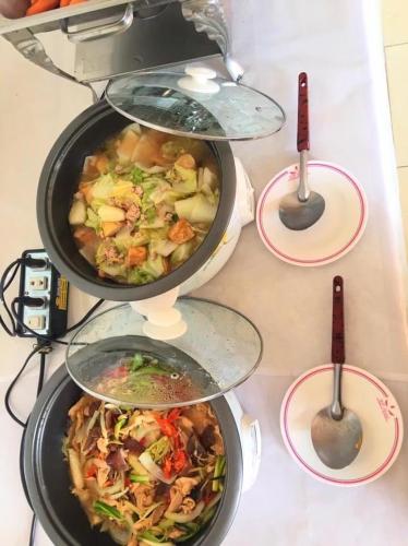 a group of four pots of food on a table at KP Hotel Udonthani in Amphoe Kumphawapi
