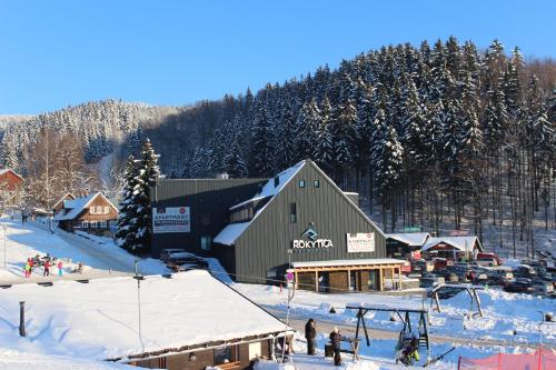 a ski lodge in the snow with a ski slope at Apartmány Rokytka Snowhouse in Rokytnice nad Jizerou