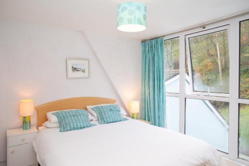 a bedroom with a bed and a large window at 5 Seabird Close Little Haven in Little Haven