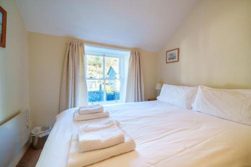 a bedroom with a white bed with towels on it at 7 Low Glenridding - with private parking in Glenridding