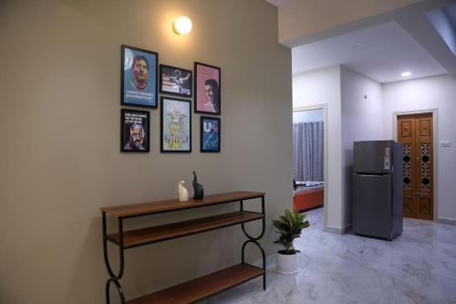 a living room with a table and a refrigerator at Aavasam - 3BHK- Gachibowli in Hyderabad