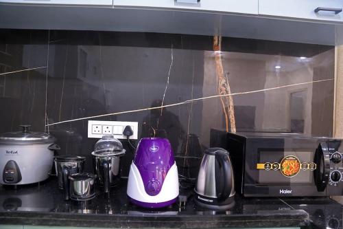 a kitchen counter with appliances on a counter top at Aavasam - 3BHK- Gachibowli in Hyderabad