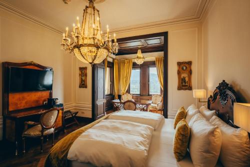 a bedroom with a bed and a chandelier at Schloss Lieser, Autograph Collection in Lieser