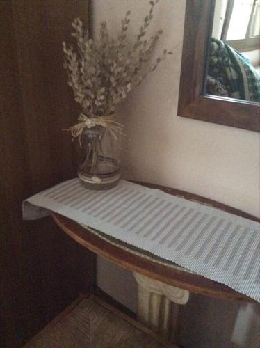 a table with a vase with flowers on it at Ey-Giann in Karpenision