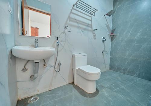 a bathroom with a toilet and a sink and a shower at Cucuu Nest Villa Coonoor by VOYE HOMES in Coonoor