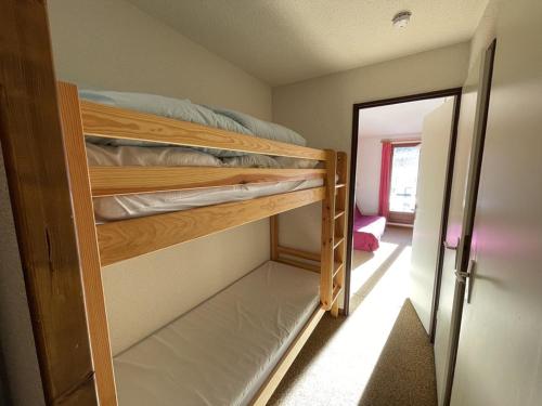 Cette chambre comprend 2 lits superposés et une porte. dans l'établissement Charmant T2 cabine au pied des pistes avec balcon et commodités - FR-1-787-85, à Laveissière