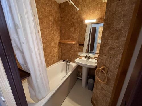 une salle de bain avec une baignoire et un lavabo et une baignoire dans l'établissement Studio confortable proche pistes ski & commerces - FR-1-787-95, à Laveissière