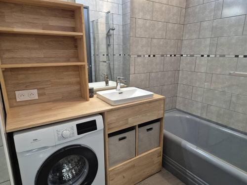 une salle de bain avec une machine à laver et un lavabo dans l'établissement T2 au Centre, Proche Télécabine et Services à Cauterets - FR-1-234-329, à Cauterets